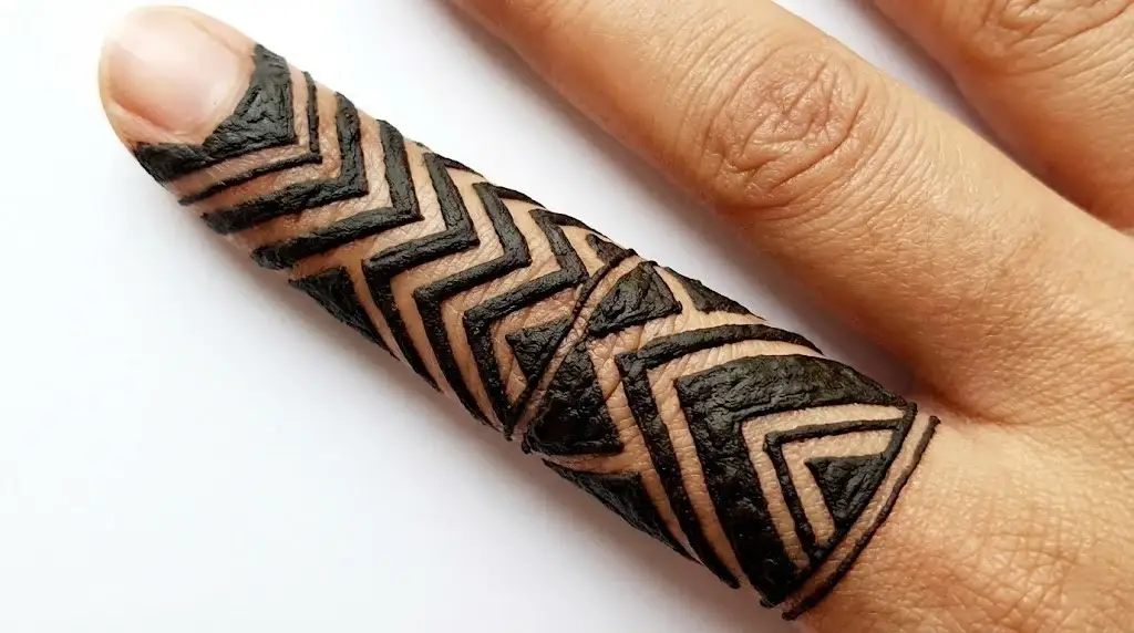 Bold tribal chevron finger mehndi design with geometric zig-zag lines and triangles.