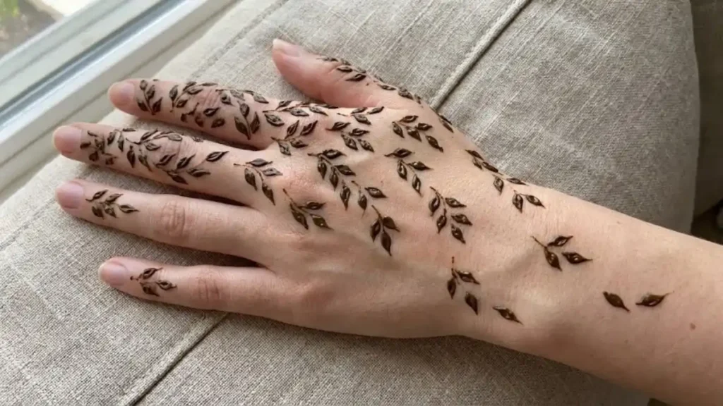 20 Stylish and Simple Back Hand Mehndi Designs 11 Delicate scattered henna leaves falling pattern on the back of the hand.