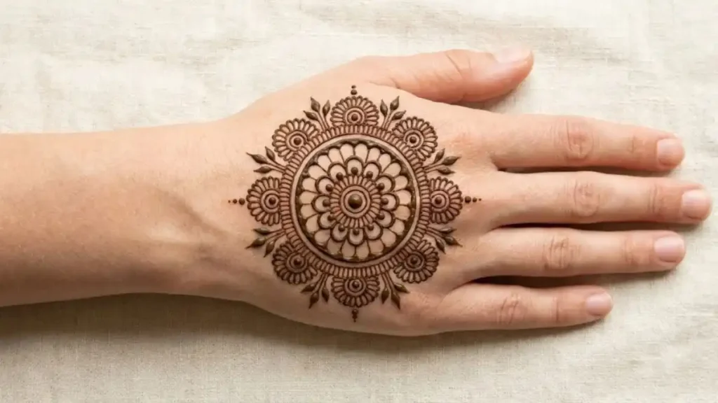 20 Stylish and Simple Back Hand Mehndi Designs 12 Simple circular floral mandala mehndi design in the center of the back hand.