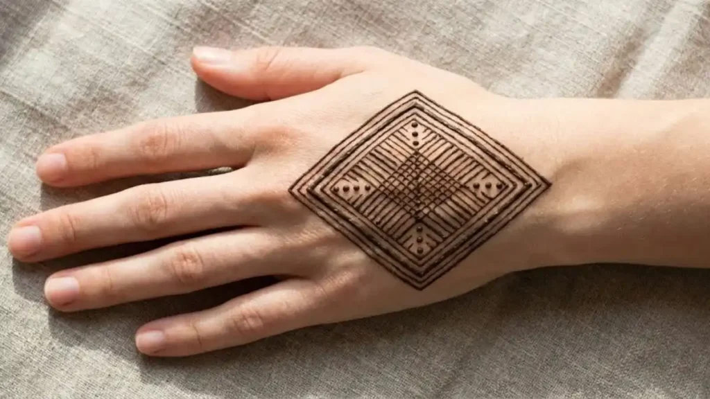 20 Stylish and Simple Back Hand Mehndi Designs 13 Modern geometric diamond shape henna pattern in the center of the back hand.