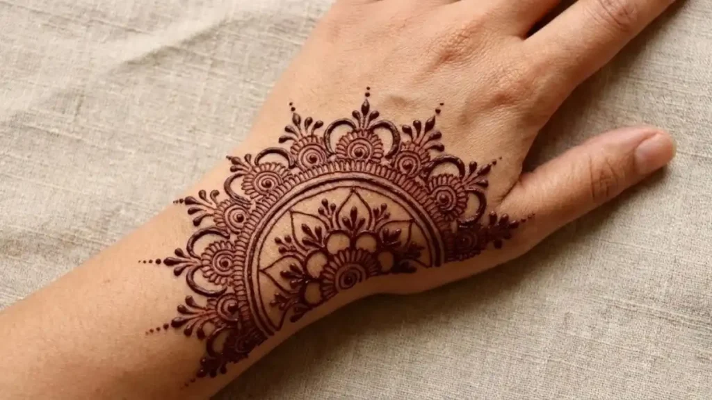 20 Stylish and Simple Back Hand Mehndi Designs 16 Half-circle mandala henna design radiating from the wrist onto the back hand.