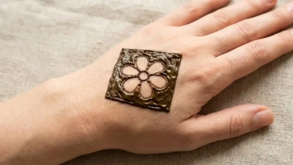 20 Stylish and Simple Back Hand Mehndi Designs 18 Negative space henna design with a flower shape left empty inside a solid square.