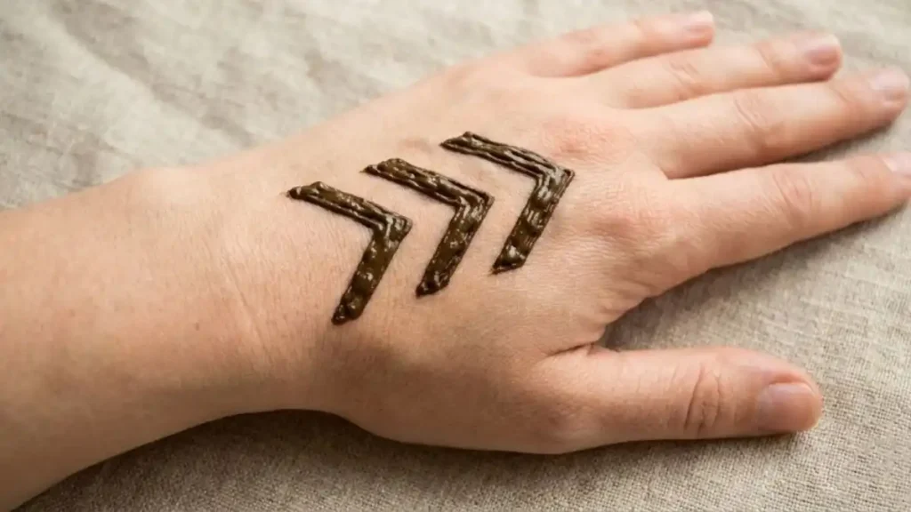 20 Stylish and Simple Back Hand Mehndi Designs 19 Bold V-shape chevron arrow henna patterns pointing towards fingers.