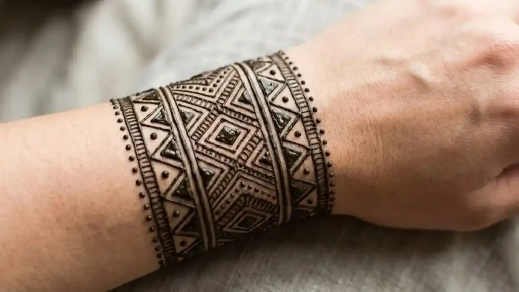 20 Stylish and Simple Back Hand Mehndi Designs 3 Wide wrist cuff mehndi design looking like a bracelet on the back of the wrist.