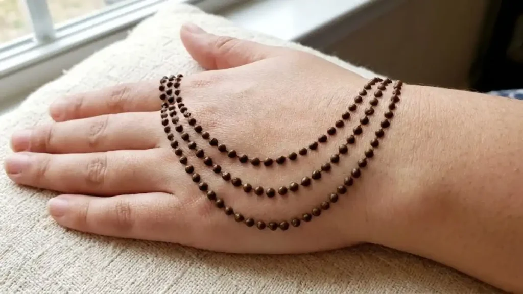 20 Stylish and Simple Back Hand Mehndi Designs 5 Three draped chains made of henna dots across the back of the hand.