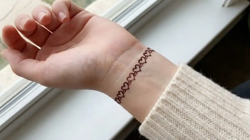 20 Stylish and Simple Back Hand Mehndi Designs 6 Simple henna bracelet design made of small linked heart shapes on the wrist.