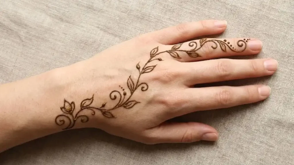 20 Stylish and Simple Back Hand Mehndi Designs 7 Single leafy floral henna vine running from wrist up the index finger on the back hand.