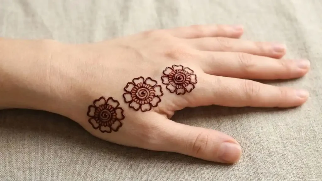 20 Stylish and Simple Back Hand Mehndi Designs 9 Three simple henna rose flowers in a diagonal line on the back of the hand.